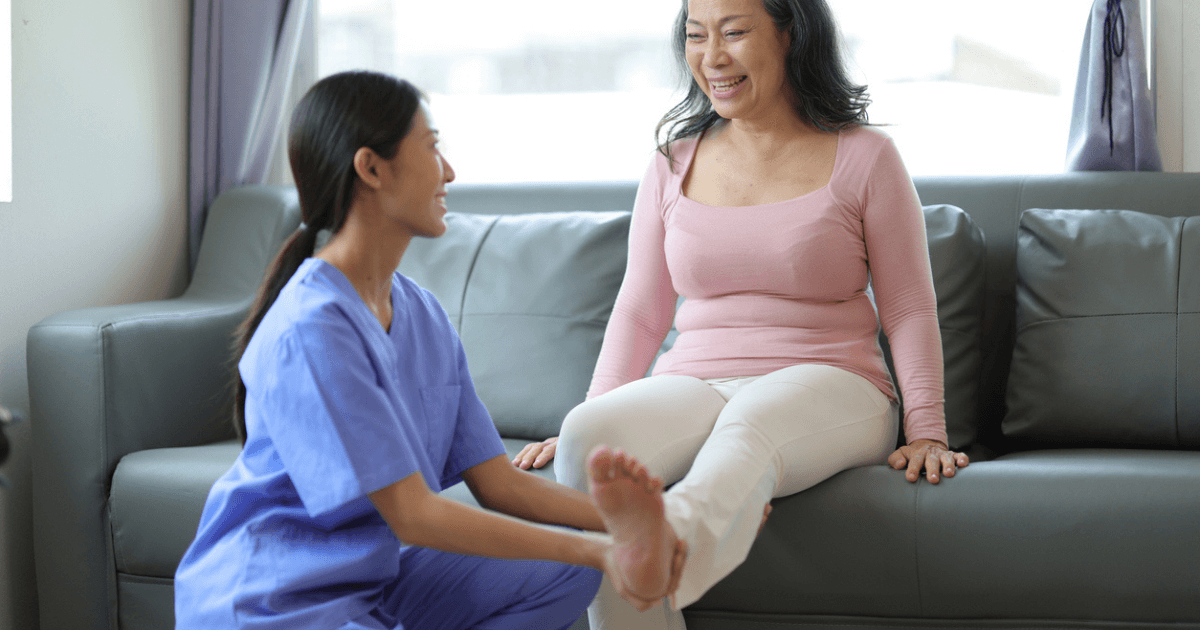 Caregiver with assisted living holding elder woman's ankle