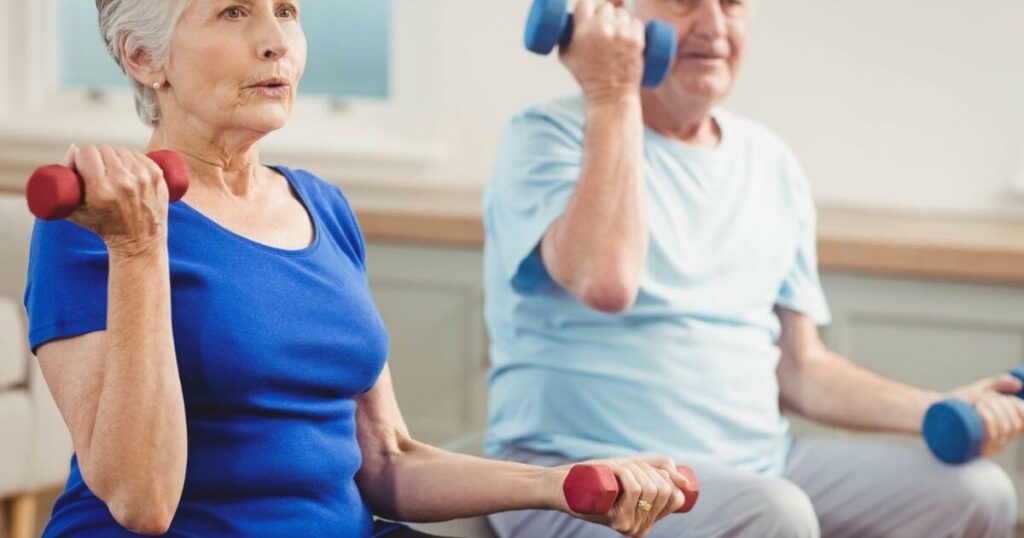 Two elder adults enhancing their senior whole health by lifting weights.
